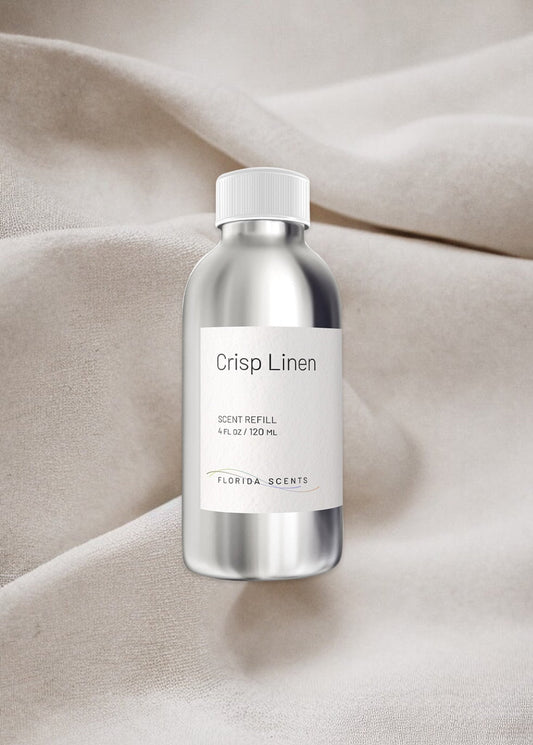 Crisp Linen Scent Refill by Florida Scents Essentials in a sleek silver bottle, placed on soft beige fabric. Ideal for refreshing home fabrics.