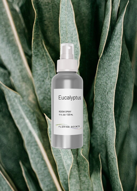 Eucalyptus Room Spray by Florida Scents Essentials, 4 fl oz bottle with minimalist label, set against fresh eucalyptus leaves background.