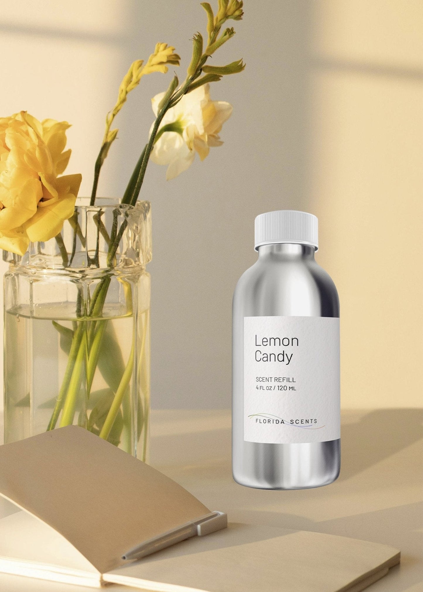 Florida Scents Essentials Lemon Candy Scent Refill bottle on a desk with yellow flowers, perfect for uplifting home ambiance and decor.