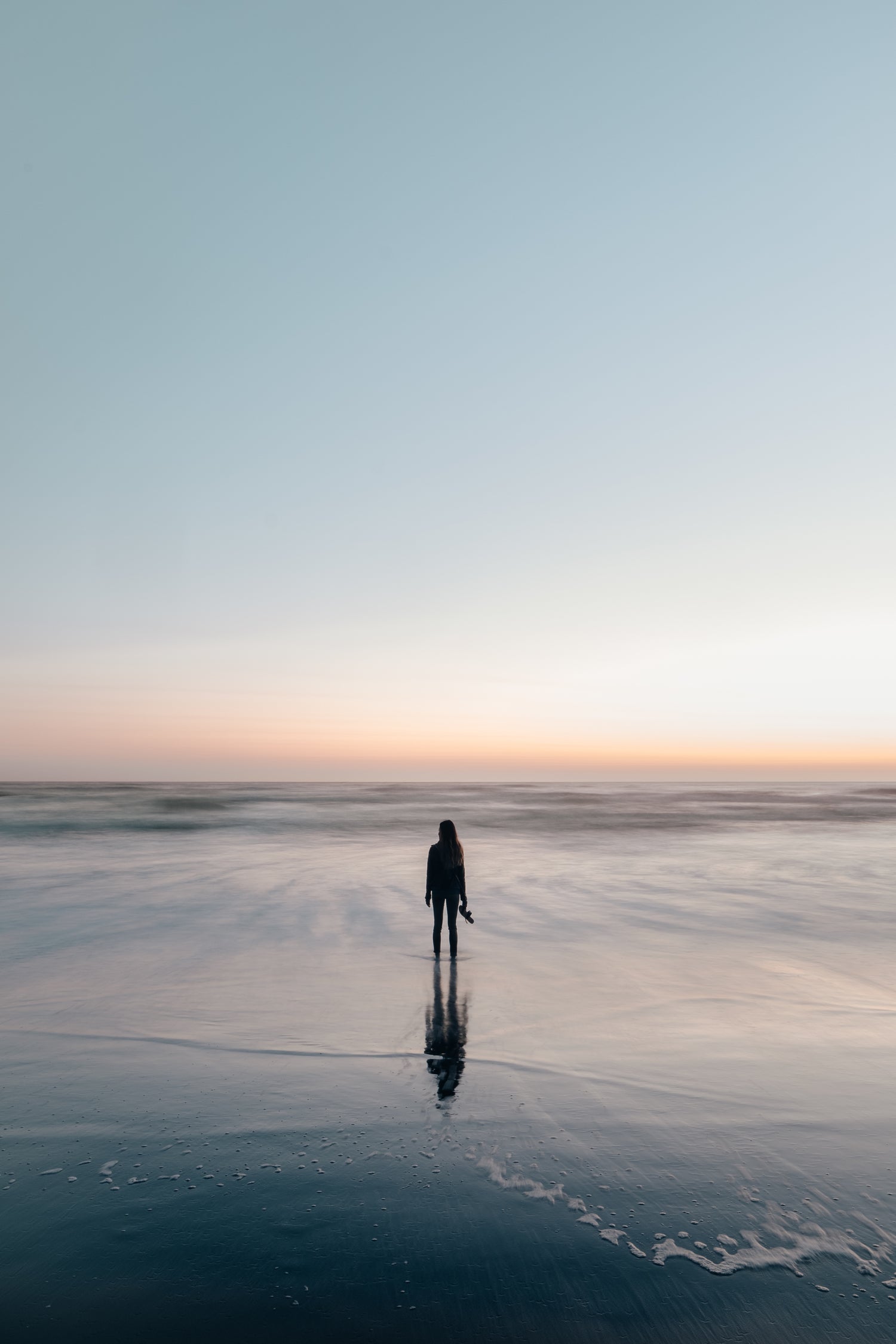 woman-wades-in-ocean-at-sunset